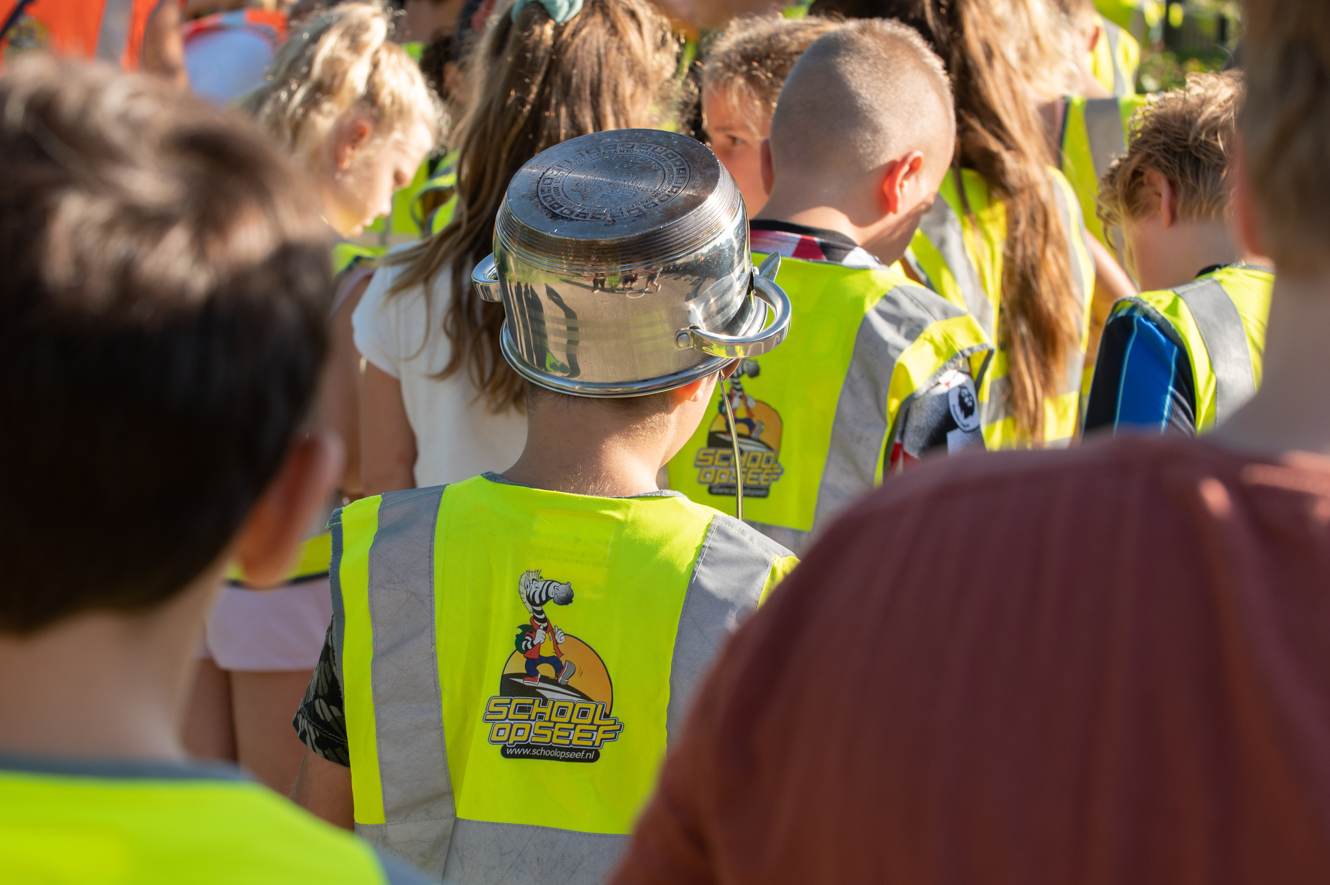 Schoolkinderen in een optocht door wijk tijdens de schoolbrengweek